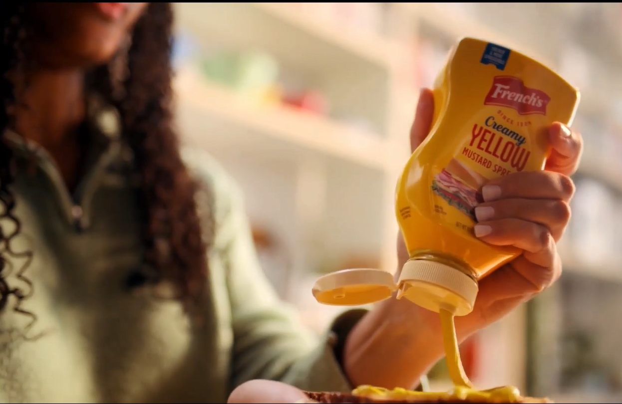 Woman squeezing a French's Mustard bottle